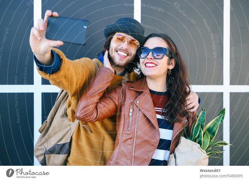 Glückliches junges Paar macht Selfie mit Smartphone Selfies Pärchen Paare Partnerschaft iPhone Smartphones Mensch Menschen Leute People Personen Handy