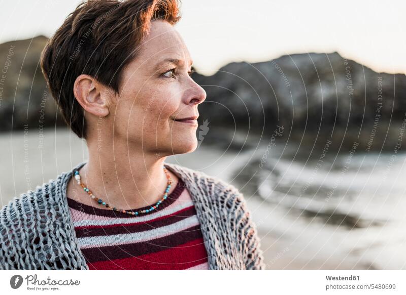 Frankreich, Halbinsel Crozon, Porträt einer Frau am Strand bei Sonnenuntergang lächeln Portrait Porträts Portraits Sonnenuntergänge Urlaub Ferien weiblich
