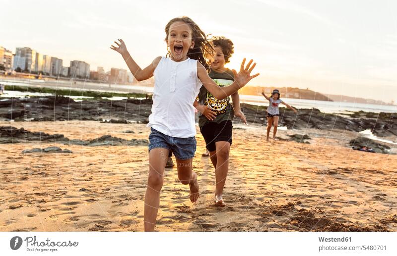Kinder, die bei Sonnenuntergang am Strand rennen spielen Freunde Beach Straende Strände Beaches Mädchen weiblich Freundschaft Kameradschaft Kids Mensch Menschen