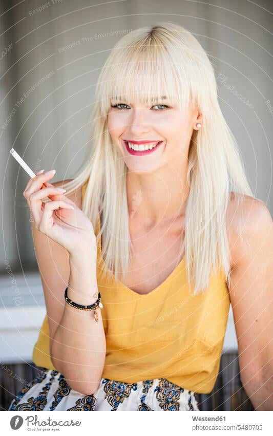 Porträt einer lächelnden blonden Frau, die Zigarette raucht rauchen weiblich Frauen Erwachsener erwachsen Mensch Menschen Leute People Personen Zigaretten