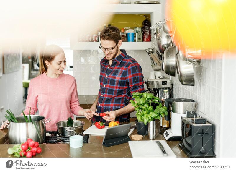 Glückliches junges Paar mit gemeinsam kochender Tablette in der Küche glücklich glücklich sein glücklichsein Tablet Computer Tablet-PC Tablet PC iPad