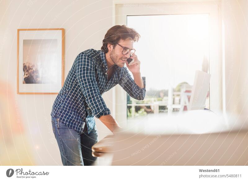 Junger Mann arbeitet im Home Office Europäer Kaukasier Europäisch kaukasisch Verbindung verbunden verbinden Anschluss Brille Brillen telefonieren anrufen Anruf