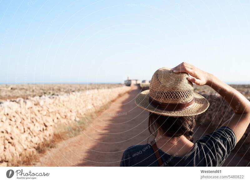 Spanien, Menorca, Rückenansicht eines Alleinreisenden mit Strohhut Frau weiblich Frauen Hut Hüte alleinreisend allein reisend Alleinreisender Erwachsener