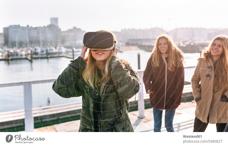 Teenagermädchen, das eine VR-Brille trägt, während ihre Freunde ihr zusehen Virtual Reality Brille Virtual-Reality-Brille Virtual Reality-Brille VR Brille