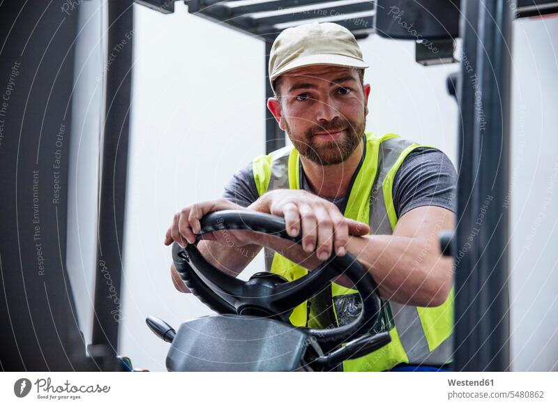 Porträt eines selbstbewussten Mannes auf einem Gabelstapler Portrait Porträts Portraits Arbeiter arbeiten Job Kraftfahrzeug Verkehrsmittel KFZ lächeln Industrie
