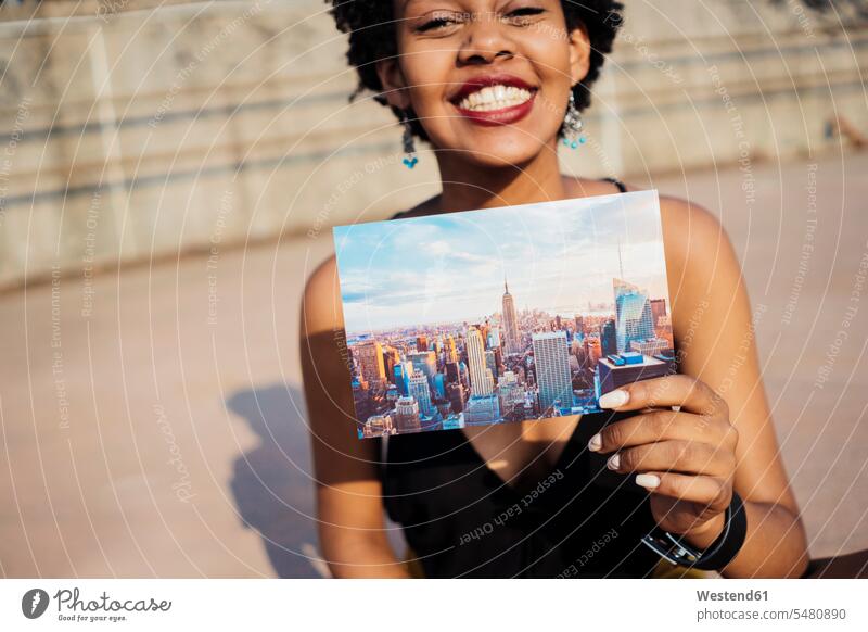 Glückliche Frau zeigt Postkarte von New York City Ansichtskarte Ansichtskarten Karte Karten Postkarten weiblich Frauen zeigen vorführen präsentieren Vorführung