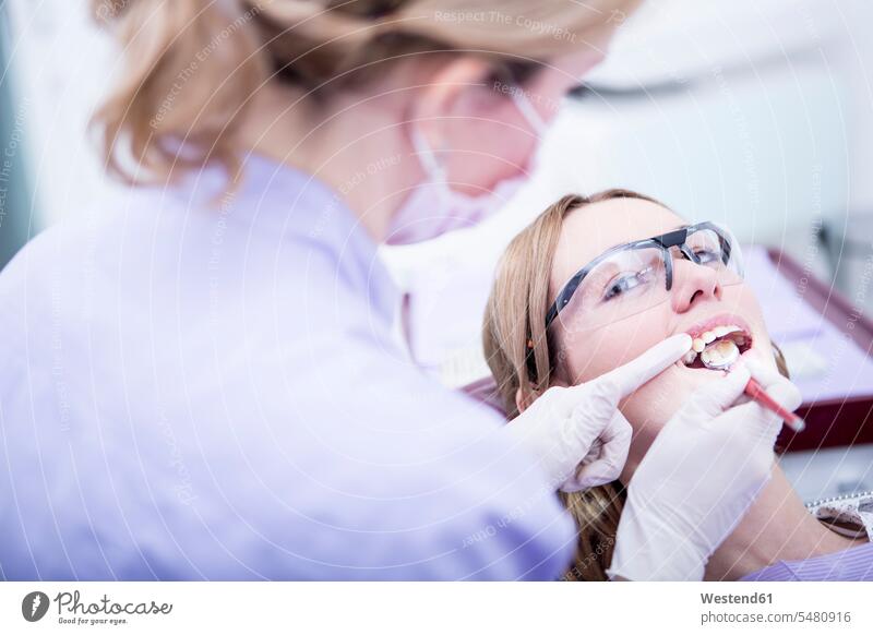 Aushärten von Zahnfüllungen beim Zahnarzt Zahnärzte Dentist Zahnaerzte Dentisten Patientin Kranke Patientinnen Frau weiblich Frauen Behandlung Krankenbehandlung