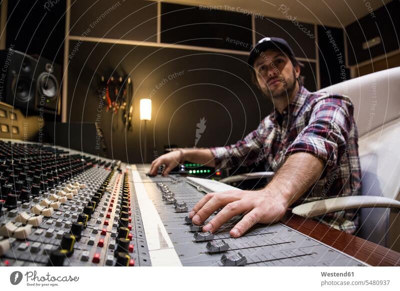 Mann, der im Kontrollraum eines Aufnahmestudios arbeitet Tonstudio Tontechniker Mischpult Männer männlich Erwachsener erwachsen Mensch Menschen Leute People
