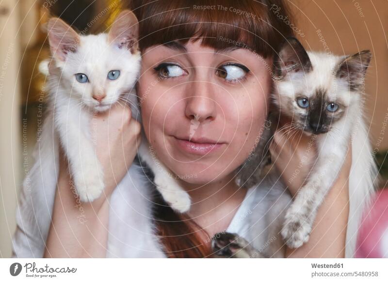 Lustiges Porträt einer jungen Frau, die zwei Kätzchen hält weiblich Frauen Portrait Porträts Portraits Katze Katzen Erwachsener erwachsen Mensch Menschen Leute