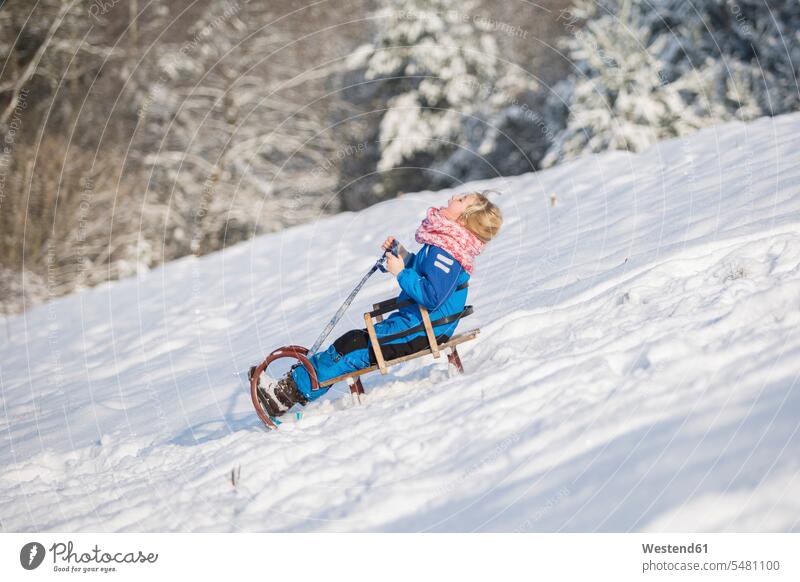 Mädchen beim Schlittenfahren bergab Europäer Kaukasier Europäisch kaukasisch Skianzug Skianzüge Skibekleidung Skikleidung Schianzug Winterbekleidung
