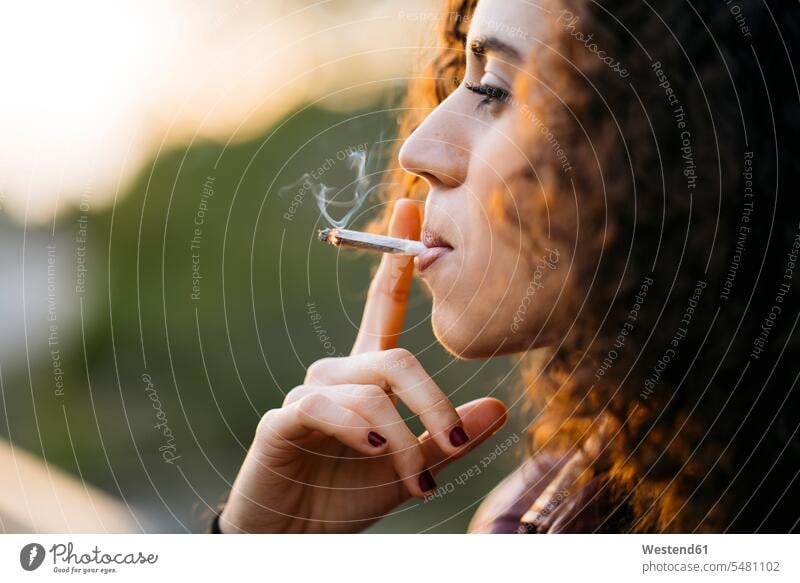 Rauchende junge Frau Zigarette Zigaretten weiblich Frauen rauchen Tabakwaren Erwachsener erwachsen Mensch Menschen Leute People Personen Qualm Abendstimmung