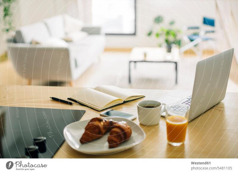 Heimbüro und Frühstück auf dem Küchentisch Kaffee Telekommunikation Verbindung verbunden verbinden Anschluss Kaffeetasse Kaffeetassen Kommunikation Wohnen