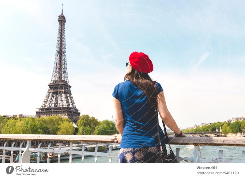 Frankreich, Paris, Rückenansicht einer Frau mit roter Baskenmütze mit Blick auf den Eiffelturm weiblich Frauen Ile-de-France Turm Türme Tuerme Bauwerk Gebäude