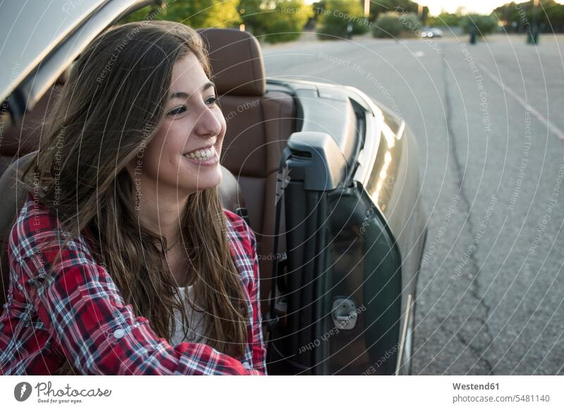 Lächelnde junge Frau sitzt im Cabrio Kabriolett Kabrios Cabriolet Cabriolets Kabrioletts Cabrios lächeln weiblich Frauen Auto Wagen PKWs Automobil Autos