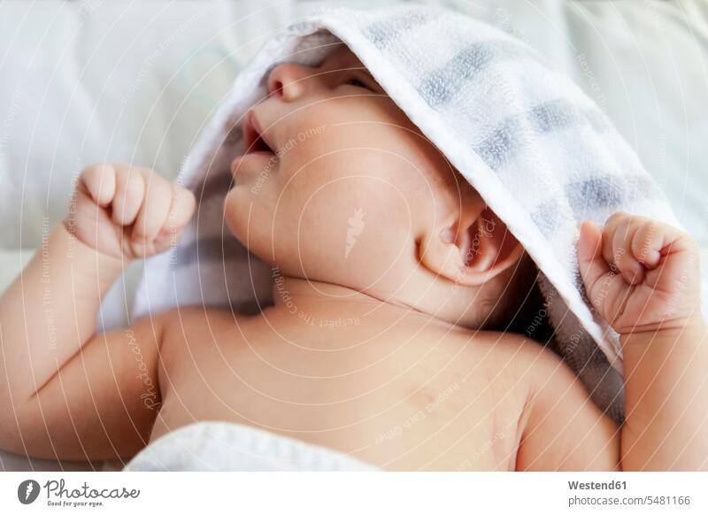Nahaufnahme eines in ein Handtuch gewickelten Babys nach dem Baden Handtuecher Handtücher liegen liegend liegt eingewickelt einwickeln verpackt eingepackt Kind
