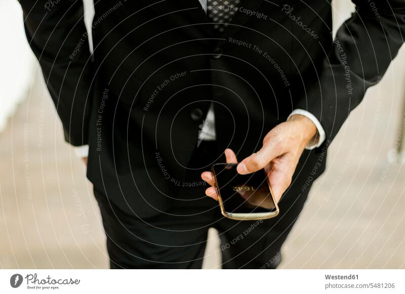 Nahaufnahme eines Geschäftsmannes, der sein Smartphone im Freien benutzt benutzen Handy Mobiltelefon Handies Handys Mobiltelefone Businessmann Businessmänner