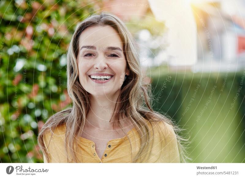 Porträt einer glücklichen Frau im Garten lächeln weiblich Frauen Portrait Porträts Portraits Glück glücklich sein glücklichsein Erwachsener erwachsen Mensch