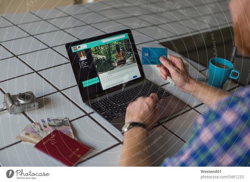 Mann benutzt Kreditkarte und Laptop zu Hause EC-Karte Kreditkarten Männer männlich Notebook Laptops Notebooks benutzen benützen Zuhause daheim bargeldlos