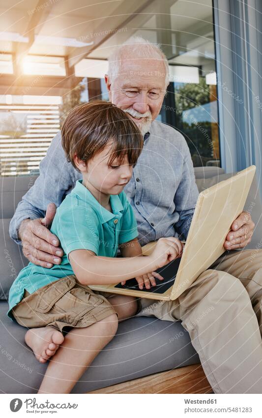 Großvater und Enkel zeichnen auf laptopförmiger Tafel spielen Zeichnung Enkelsöhne Enkelsohn Opa Großpapa Großpapas Opas Opi Großväter Opis Laptop Notebook