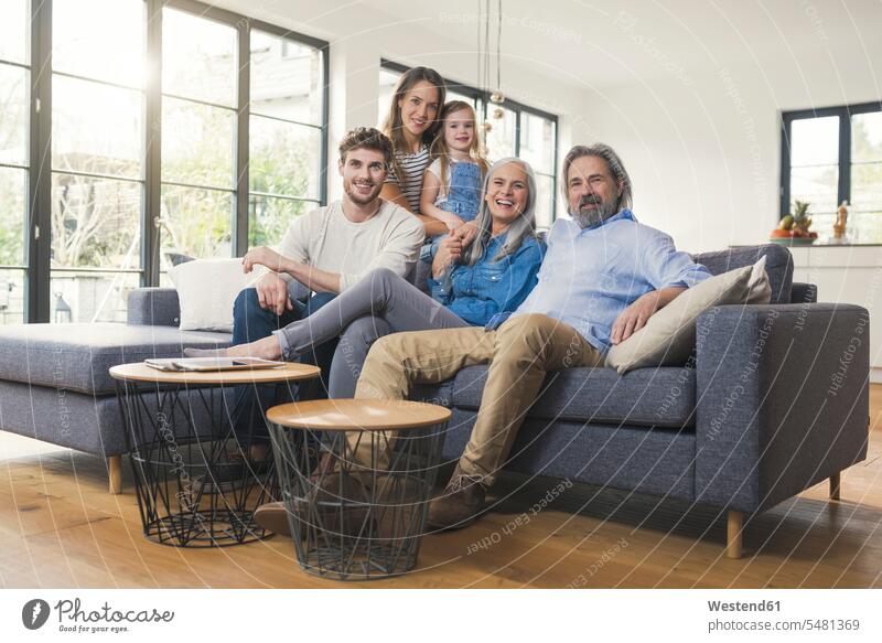 Großfamilie sitzt auf dem Sofa und lächelt glücklich Glück glücklich sein glücklichsein Couches Liege Sofas Zuhause zu Hause daheim sitzen sitzend Gemeinsam