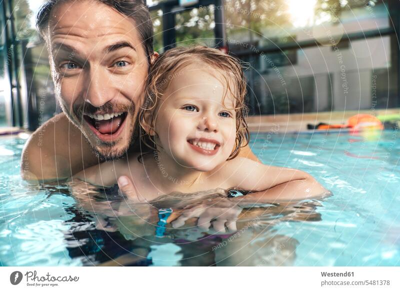Porträt eines glücklichen Vaters mit Tochter im Hallenbad Schwimmbad Schwimmbaeder Schwimmbäder Portrait Porträts Portraits Töchter Glück glücklich sein