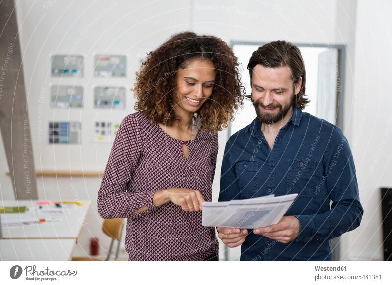 Zwei Kollegen besprechen Papiere im Amt arbeiten Arbeit Arbeitskollegen Büro Office Büros Arbeitsplatz Arbeitsstätte Arbeitstelle lächeln Tablet Tablet Computer