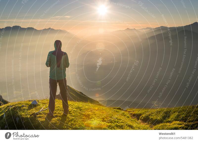 Österreich, Tirol, Wanderer, der bei Sonnenaufgang in die Ferne schaut reisen Travel verreisen Weg Reise stehen stehend steht Aussichtspunkt Sonnenaufgänge Mann