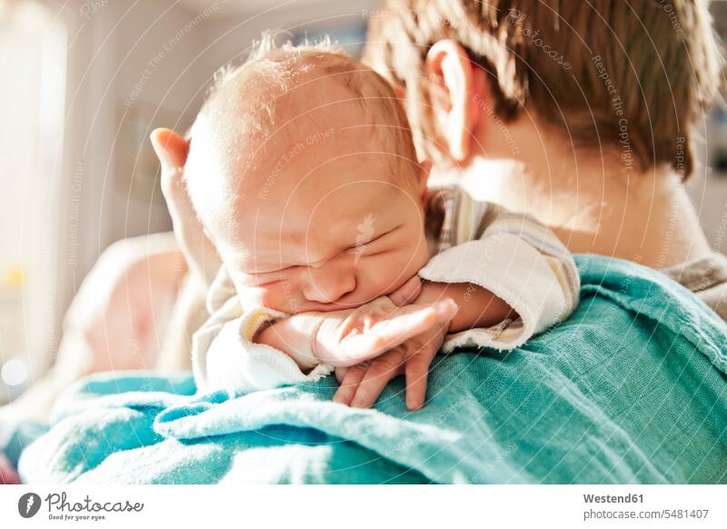 Nahaufnahme eines Vaters, der seinen neugeborenen Sohn über die Schulter hält Papas Väter Vati Vatis Papis Kind Babies Babys Kinder Söhne Eltern Familie