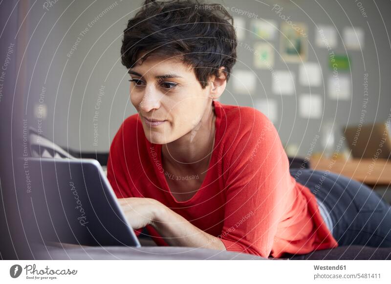 Frau benutzt Tablette zu Hause Tablet Computer Tablet-PC Tablet PC iPad Tablet-Computer Zuhause daheim weiblich Frauen Rechner Erwachsener erwachsen Mensch