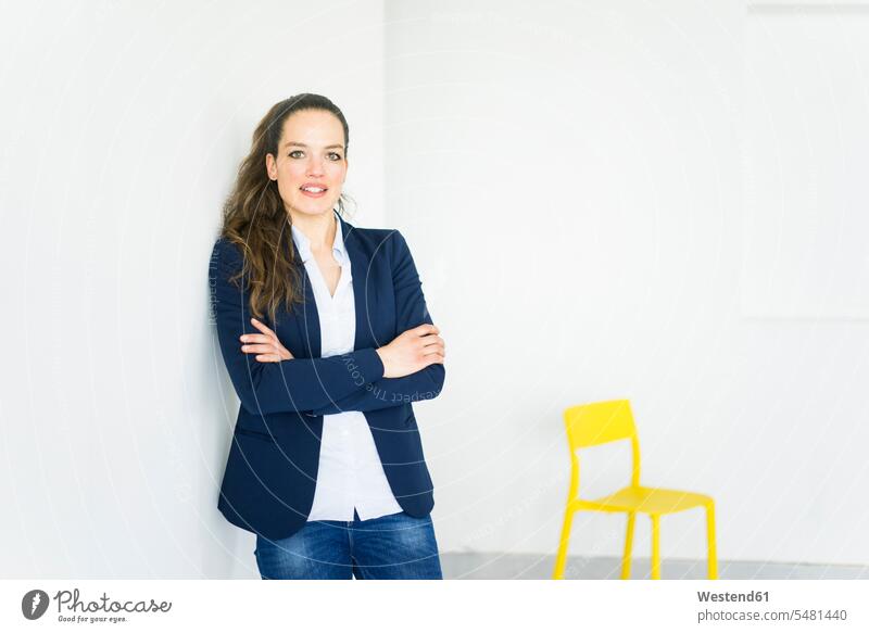 Porträt einer Geschäftsfrau in einem Raum mit gelbem Stuhl Frau weiblich Frauen Geschäftsfrauen Businesswomen Businessfrauen Businesswoman stehen stehend steht