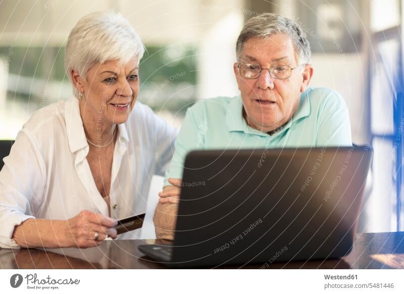 Älteres Ehepaar kauft online mit Kreditkarte ein Shopping einkaufen shoppen Einkauf Online Senior ältere Männer älterer Mann Senioren EC-Karte Kreditkarten Paar