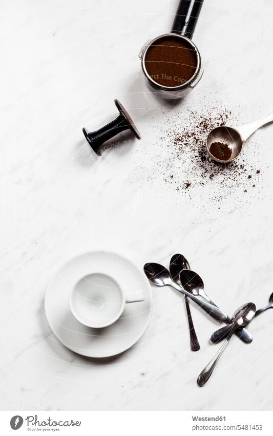 Leere Espressotasse, Löffel und Druckportafilter auf weißem Marmor weißes weißer weiss Teelöffel Teeloeffel Espressotassen Kaffeepulver Dinge die zusammenpassen