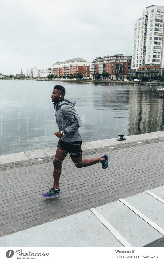 Irlenad, Dublin, junger Mann rennt an der Uferpromenade laufen rennen Männer männlich trainieren Joggen Jogging Erwachsener erwachsen Mensch Menschen Leute