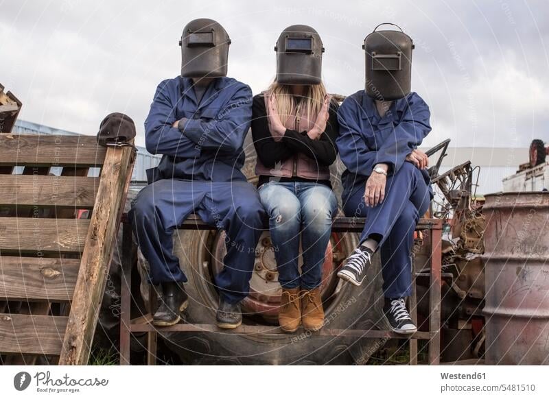 Drei Personen mit Schweißerhelmen im Freien Kollegen Arbeitskollegen Arbeiter Schweißmaske Schweißhelm Job Frau mittleren Alters Frauen mittleren Alters