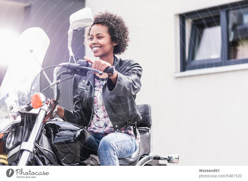 Lächelnde junge Frau auf ihrem Motorrad weiblich Frauen lächeln Motorräder Erwachsener erwachsen Mensch Menschen Leute People Personen Kraftfahrzeug