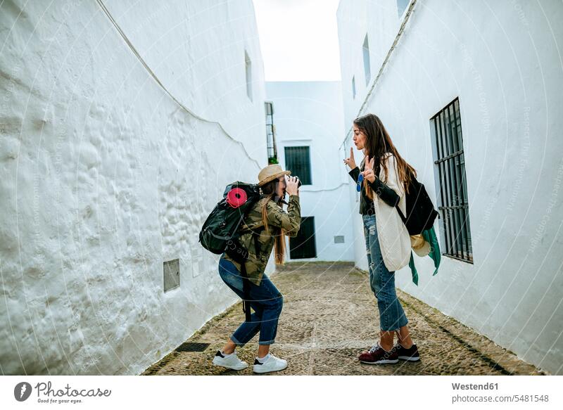Junge reisende Frauen fotografieren in einer Stadt Freundinnen Fotoapparat Kamera Fotokamera Freunde Freundschaft Kameradschaft staedtisch städtisch weiblich