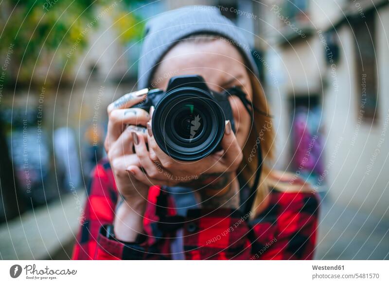 Junge Frau, die den Betrachter mit einer Spiegelreflexkamera fotografiert weiblich Frauen Kamera Kameras fotografieren Erwachsener erwachsen Mensch Menschen