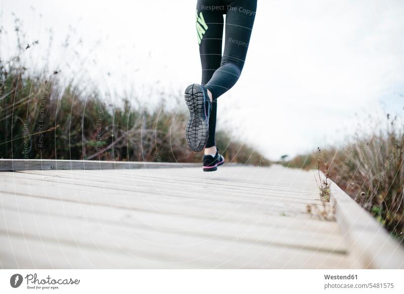 Spanien, Tarragona, Frau rennt auf einem Laufsteg Laufschuh Laufschuhe Schuhsohle Sohle Schuhsohlen Sohlen Sportschuh Sportschuhe Steg Gesunder Lebensstil