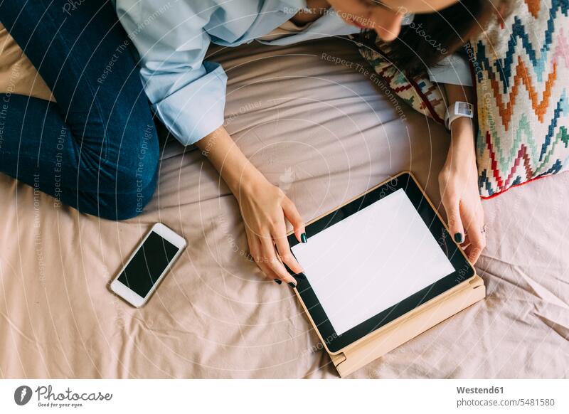 Junge Frau mit digitalem Tablet am Bett, Smartphone weiblich Frauen Tablet Computer Tablet-PC Tablet PC iPad Tablet-Computer Erwachsener erwachsen Mensch
