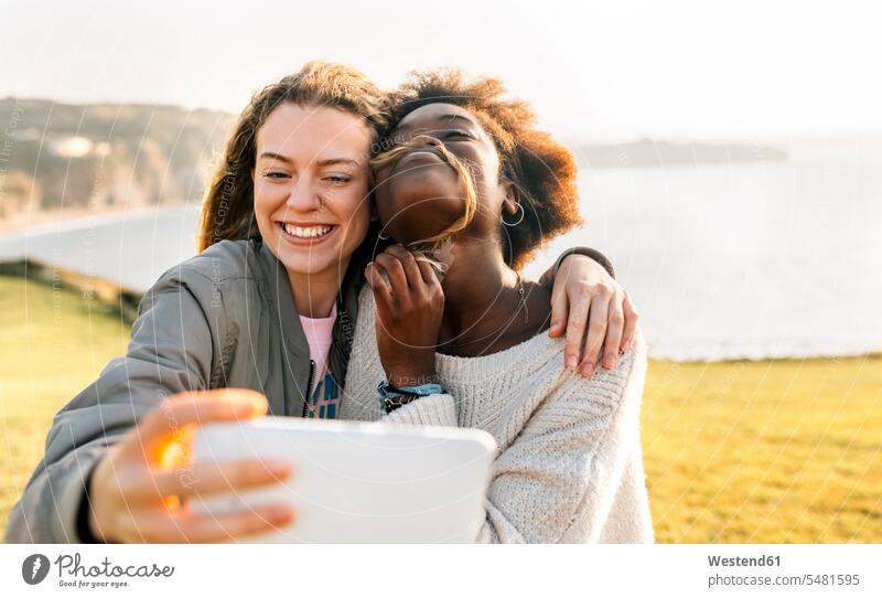 Zwei glückliche beste Freunde machen ein Selfie an der Küste Freundinnen Frau weiblich Frauen Glück glücklich sein glücklichsein Handy Mobiltelefon Handies