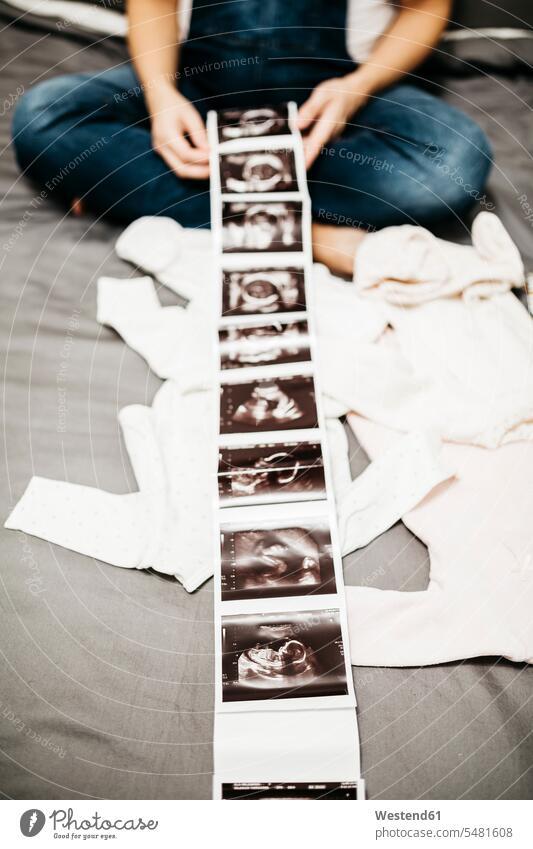 Schwangere, die sich Ultraschallbilder anschaut, Teilansicht Ulgtraschall Schwangerschaft schwanger Ultraschalluntersuchung Sonographie Echographie