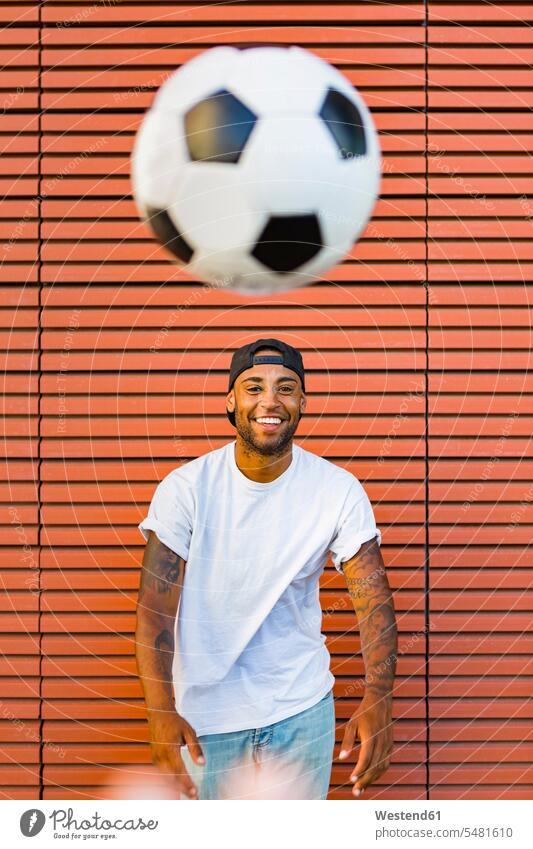 Porträt eines lachenden Mannes, der sich mit Fussball vergnügt Portrait Porträts Portraits Männer männlich Fußball Fußbälle Erwachsener erwachsen Mensch