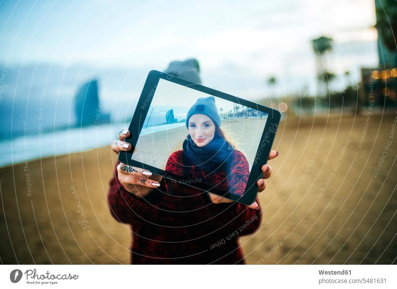 Junge Frau am Strand im Winter, die ein Selfie mit einem Tablet macht Foto Fotos Tablet Computer Tablet-PC Tablet PC iPad Tablet-Computer Selfies weiblich