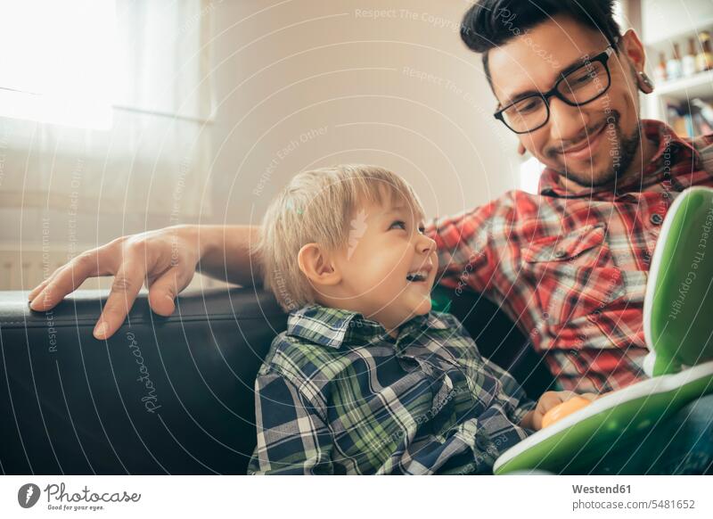 Glücklicher Vater und Sohn mit Spielzeug-Laptop Spaß Kind Familie Mensch Computer Eltern Zuhause Vorbild unangepasst sitzen Häusliches Leben Freizeit spielen