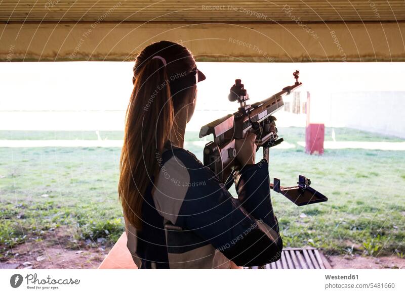 Frau vor den Zielscheiben auf einem Schießstand Gewehr Schusswaffe Gewehre Schiessstaende Schießstände Schiessstand schießen weiblich Frauen Waffe Waffen