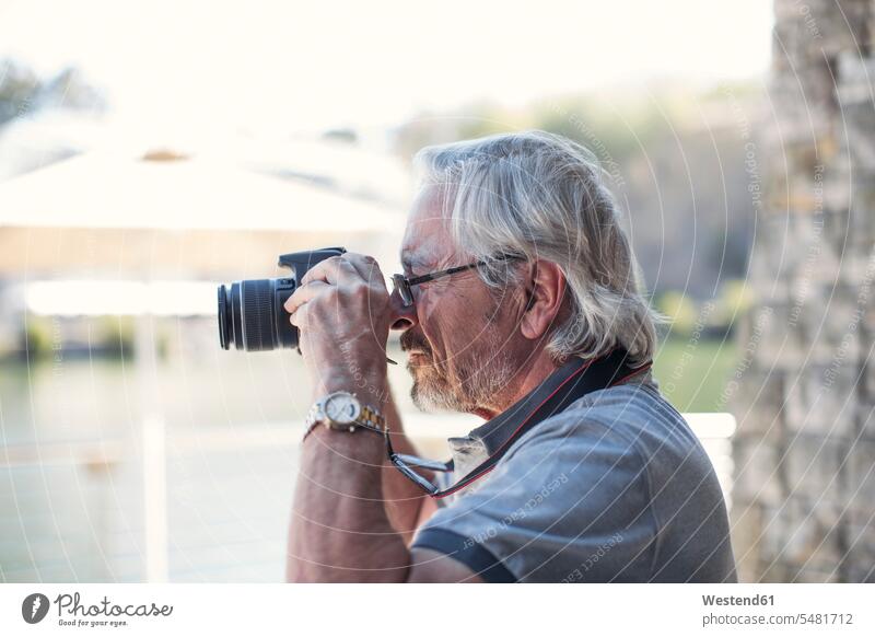 Älterer Mann, der mit seiner Kamera fotografiert unterwegs auf Achse in Bewegung Städtereise City Trip Kurztripp City Break glücklich Glück glücklich sein