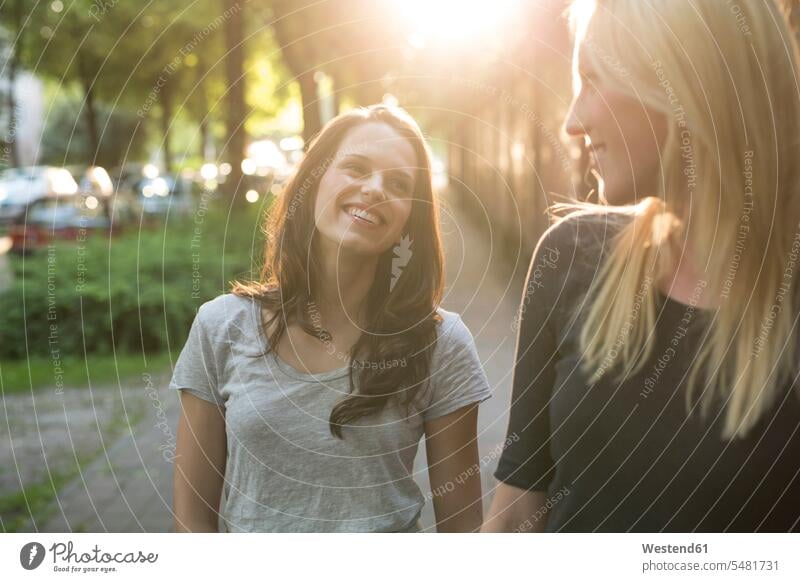 Zwei glückliche junge Frauen bei Sonnenuntergang im Freien weiblich Spaß Spass Späße spassig Spässe spaßig lächeln Freundinnen Erwachsener erwachsen Mensch