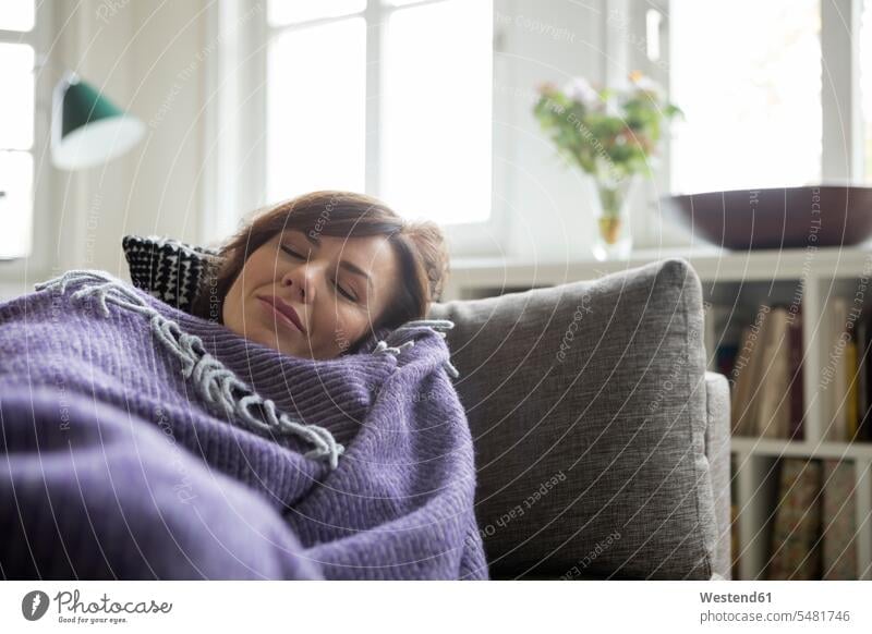Frau mit auf dem Sofa liegender Decke weiblich Frauen liegt Couches Liege Sofas krank schlafen schlafend Decken Erwachsener erwachsen Mensch Menschen Leute