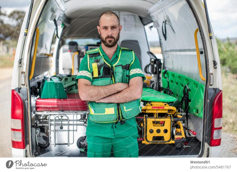 Sanitäter steht mit verschränkten Armen vor dem Krankenwagen Ambulanz Rettungsauto Krankenautos Sanitätsautos Rettungsautos Sanitätswagen Ambulanzwagen Medizin