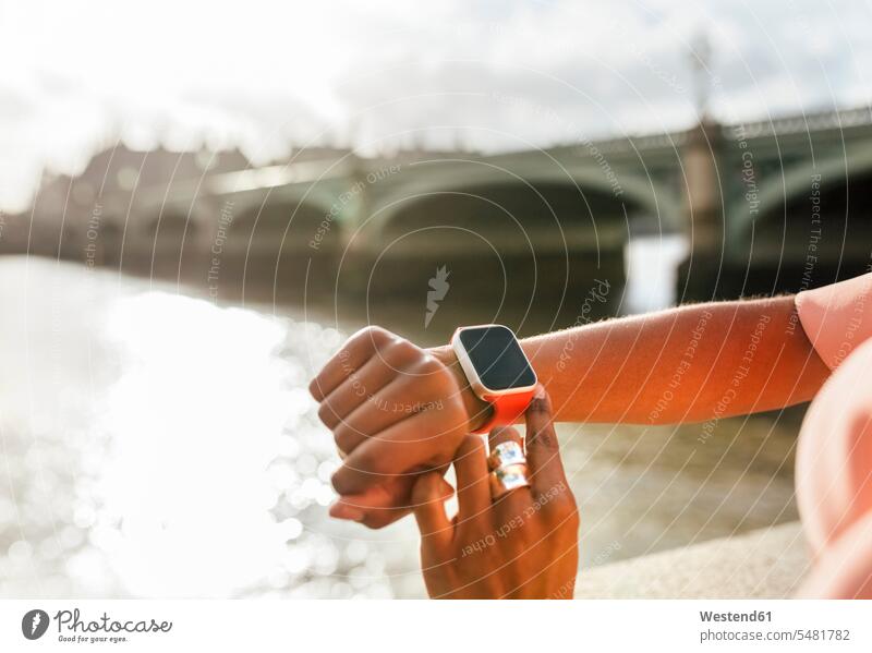 Grossbritannien, London, Nahaufnahme einer Frau, die ihre Smartwatch in der Nähe der Westminster Bridge benutzt weiblich Frauen Armbanduhr Armbanduhren